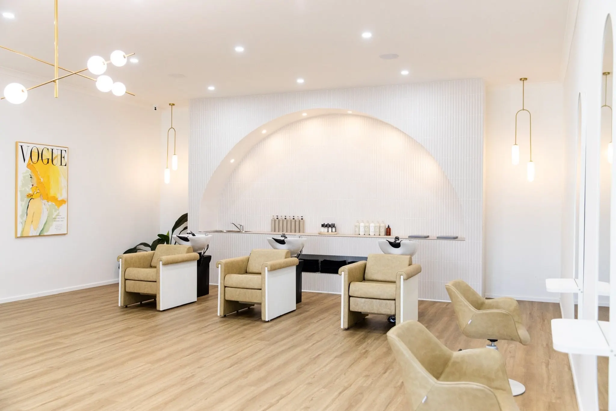 Welcoming hair salon interior with arched wash bay, gold pendant lights and leather armchairs at Ergo and Mane Bridgewater near Bendigo
